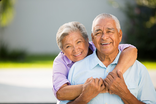 A loving senior couple hugging and posing for the camera.