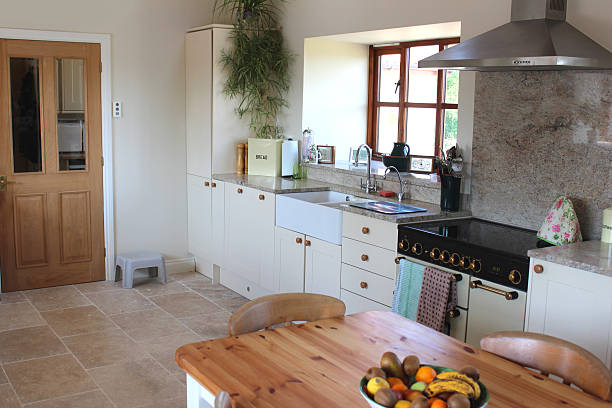 istock Country kitchen, granite worktop, gas range cooker, tiled-floor, pine table 499470373