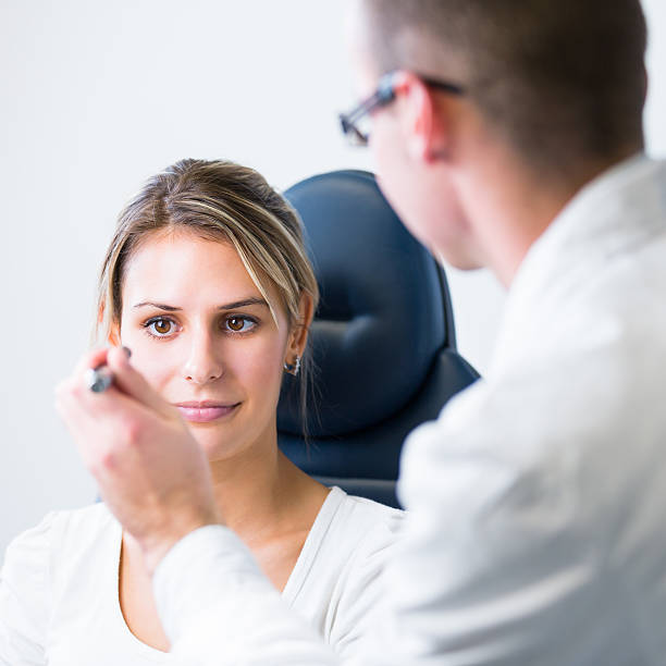 hermosa mujer joven con los ojos examinados por optometrics - doctor reading chart human eye fotografías e imágenes de stock