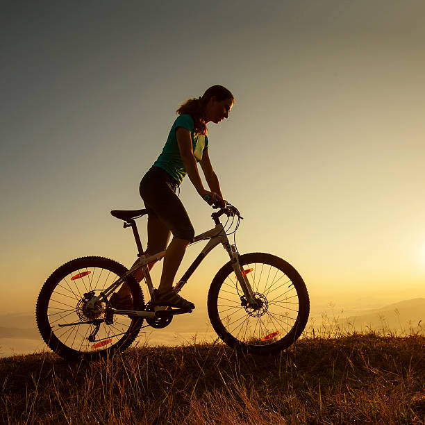 istock Biker-girl at the sunset on mountains 499476242