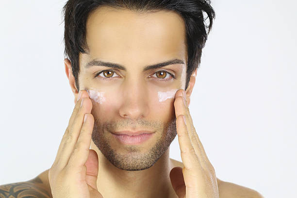 istock handsome man applying cream on his face 499476494