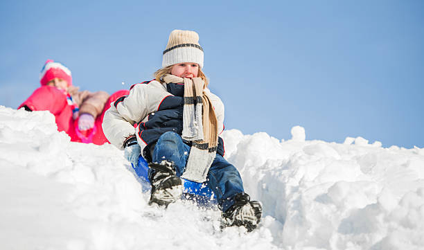 istock Little boy and girl sledging on snow. 499477260