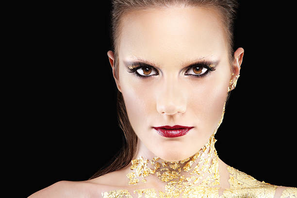 Portrait of a girl with a fiery golden make-up shot using the technique of mixed light