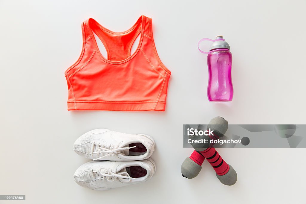 close up of sportswear, dumbbells and bottle sport, fitness, healthy lifestyle and objects concept - close up of female sports clothing, dumbbells and bottle set Gym Stock Photo