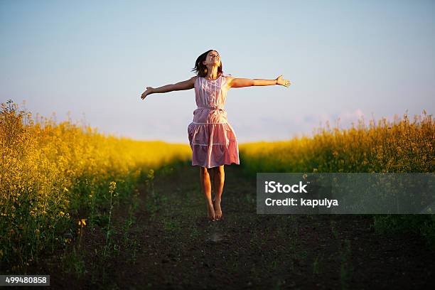 Happy Woman Jumps To The Sky In The Yellow Meadow Stock Photo - Download Image Now - 2015, Adult, Beauty