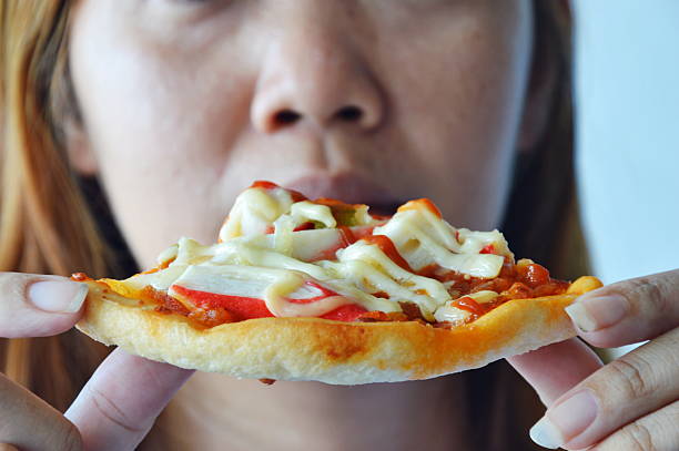 istock woman eating pizza 499481340