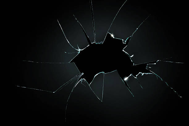 istock broken cracked glass with big hole over black background 499482412