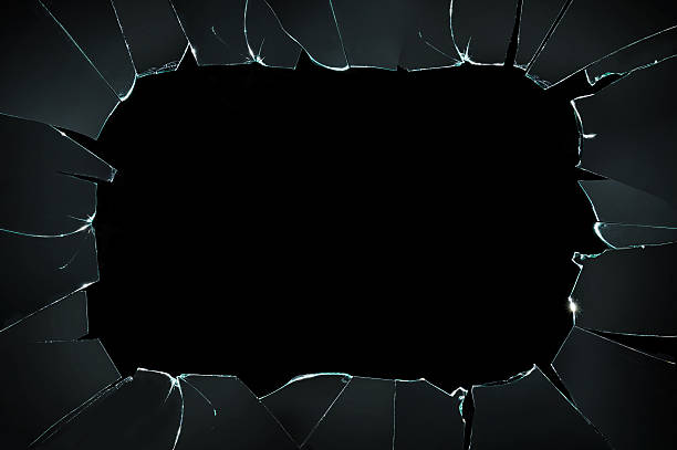 istock broken cracked glass with big hole over black background 499482450