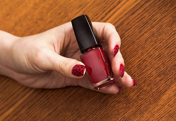 Female Hand With Red Manicure Holding Bottle Of Nail Polish Stock Photo -  Download Image Now - iStock