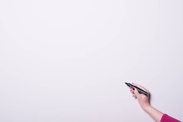 istock woman's hand with pen on whiteboard with copy space 499486306