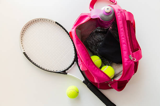 close up of tennis stuff and female sports bag sport, fitness, healthy lifestyle and objects concept - close up of tennis racket and balls with female sports bag tennis ball container stock pictures, royalty-free photos & images