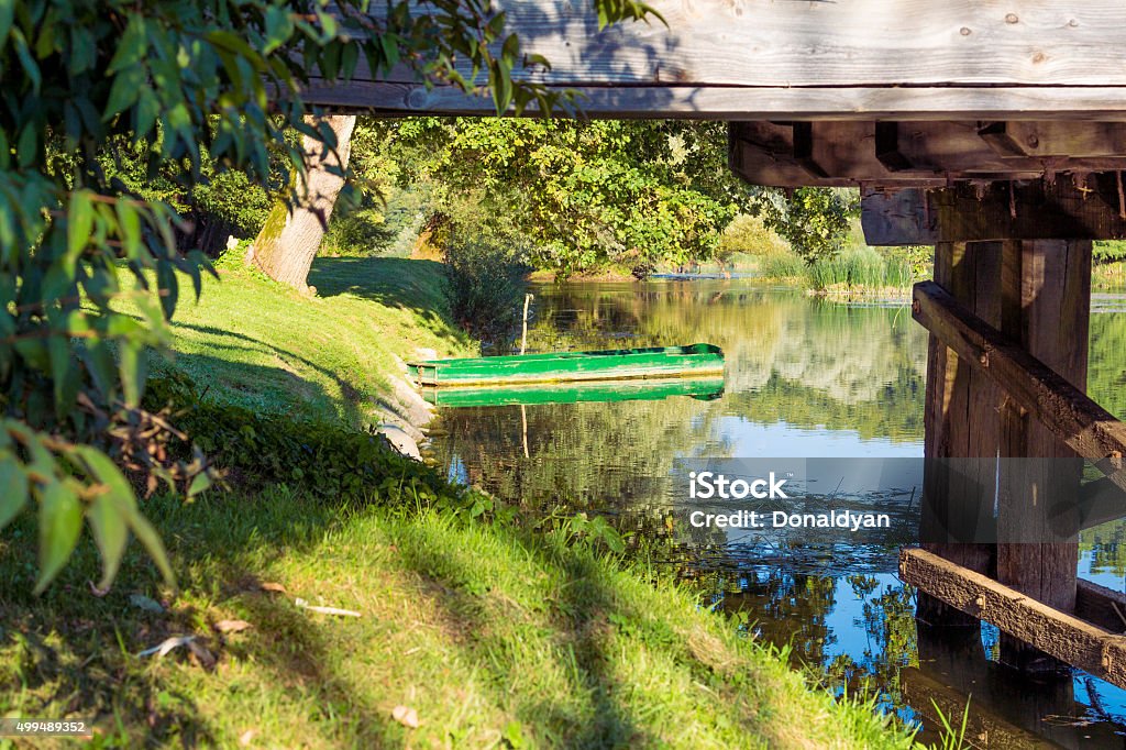 Green boat. Green boat parked behind old wooden bridge. 2015 Stock Photo