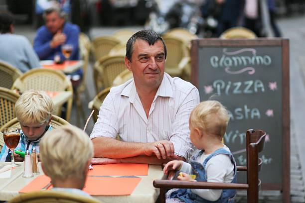 istock Family eating and drinking in outdoors italian cafe 499492193
