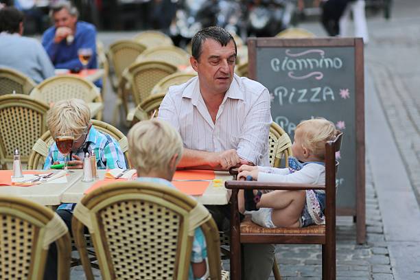 istock Family eating and drinking in outdoors italian cafe 499492207