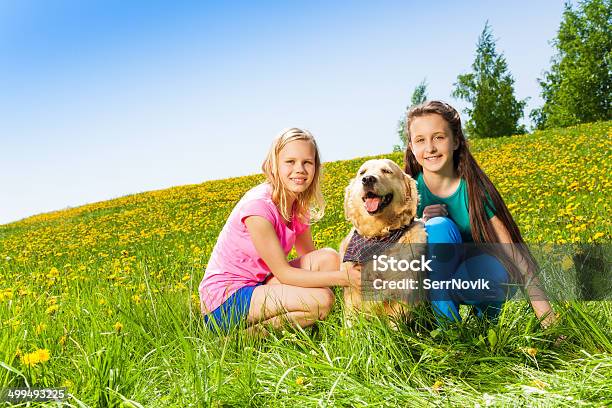 Two Girls Sitting Near To Dog On Green Grass Stock Photo - Download Image Now - Agricultural Field, Animal, Beautiful People