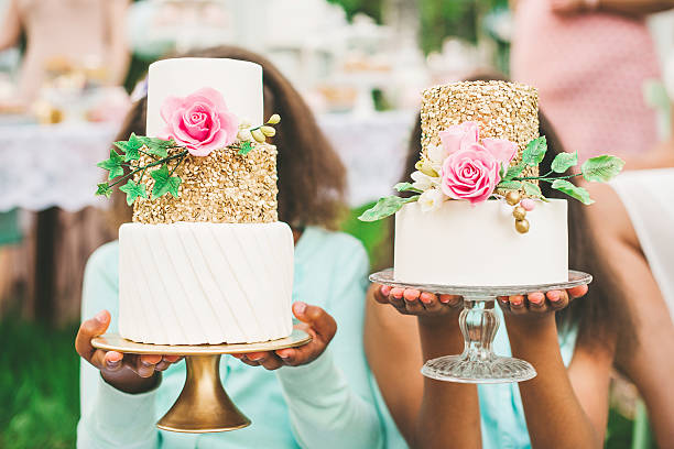 Two girls holding up beautiful cakes