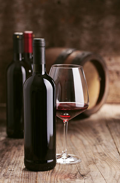 istock Wine bottles with barrel on wooden background 499495401