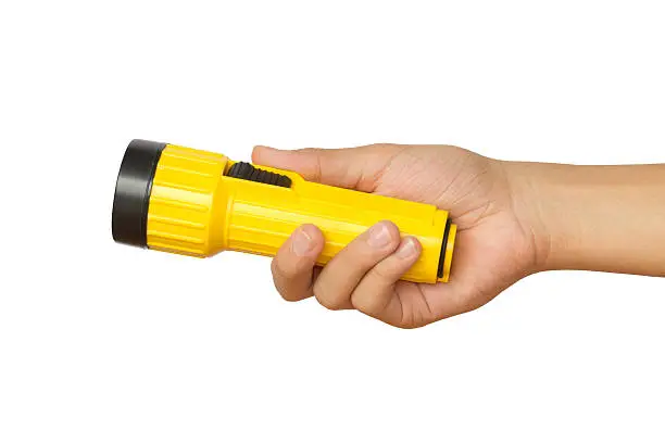 Hand holding yellow flashlight over white background - concepts of searching and direction