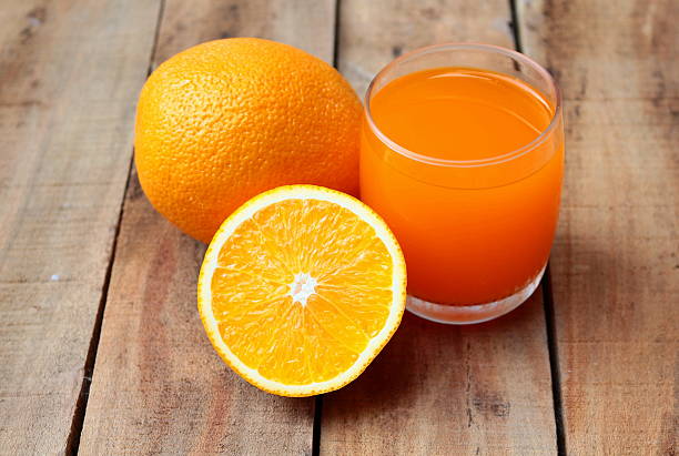 istock Orange juice on wooden background 499505984
