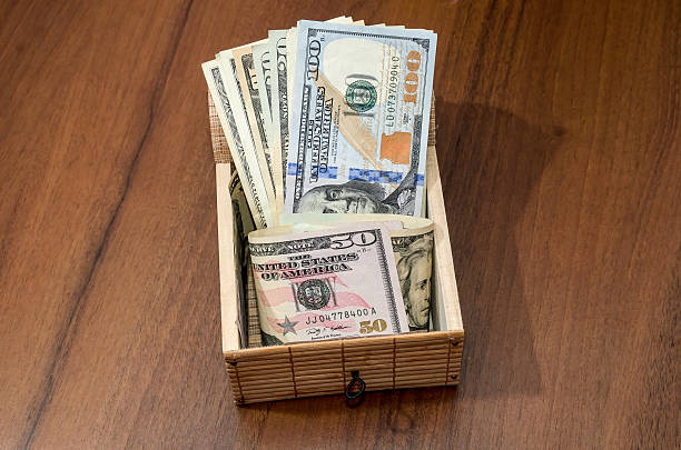 istock treasure chest with dollars on wooden background 499510604
