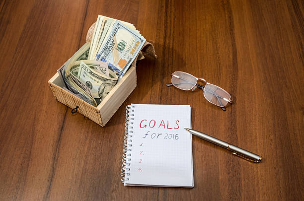 istock GOALS text written on notebook with dollar in box, pen 499510858