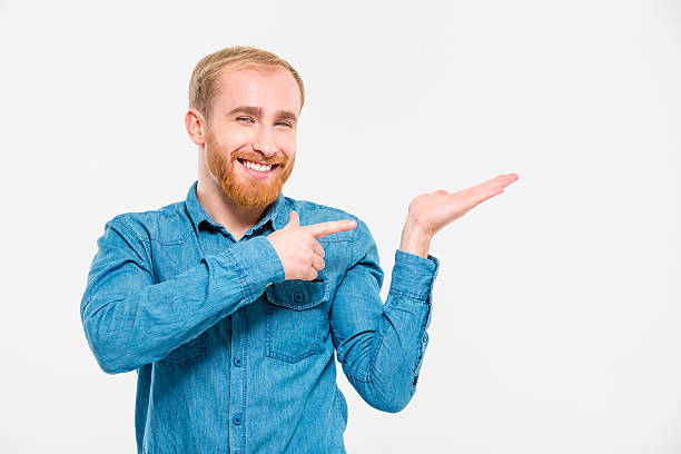 istock Happy smiling young man with beard holding copyspace on palm 499511550