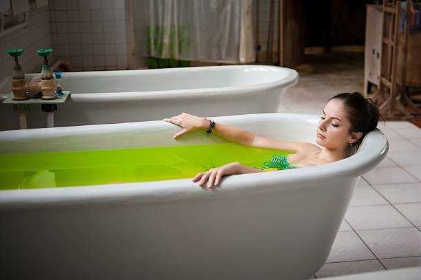 istock Woman in a bathtub with green water 499511708