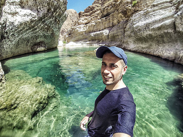oman, selfie in natürlichen pool im wadi tiwi - tiwi stock-fotos und bilder
