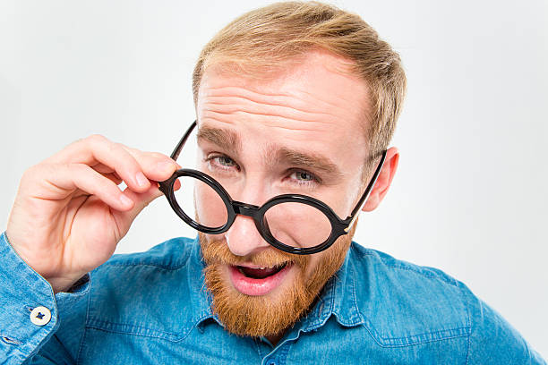 istock Amusing happy man with beard looking over his round glasses 499513028