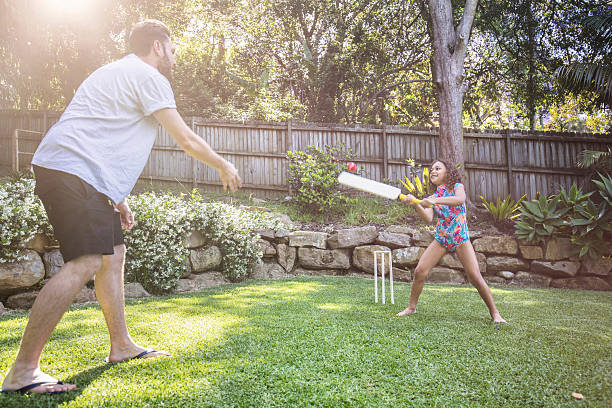 pai e filha jogando críquete no jardim - indigenous culture aborigine australia australian culture - fotografias e filmes do acervo