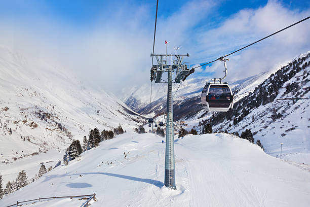 Chairs on ski rope lift over the mountains on background on winter ski resort in Sochi, Russia, Europe