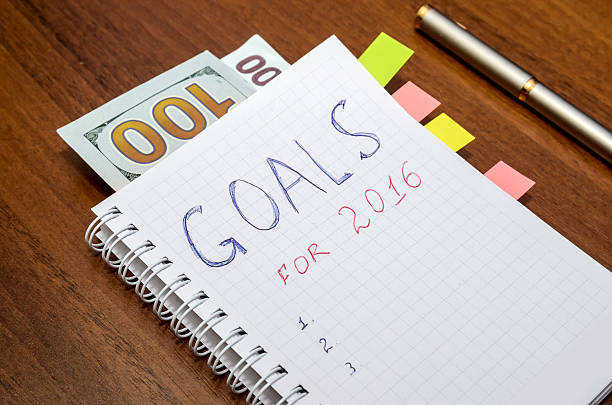 istock Notebook with text goals of year 2016 with dollar 499514590