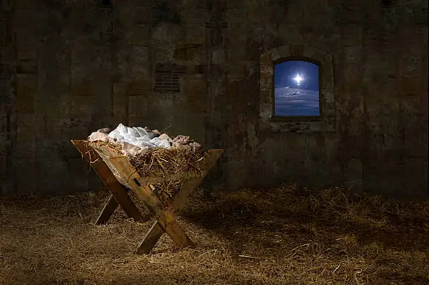 Manger in barn with window showing Christmas star