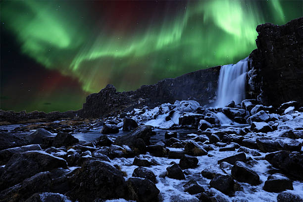 Northern Lights and Oxararfoss Waterfall in Thingvellir Iceland stock photo