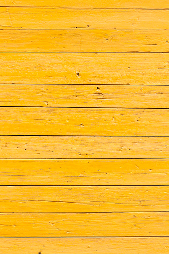 vertical picture of old horizontal planks with bright yellow paint
