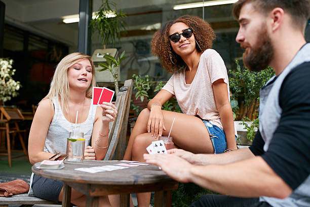 istock Group of young people playing cards at cafe 499516782
