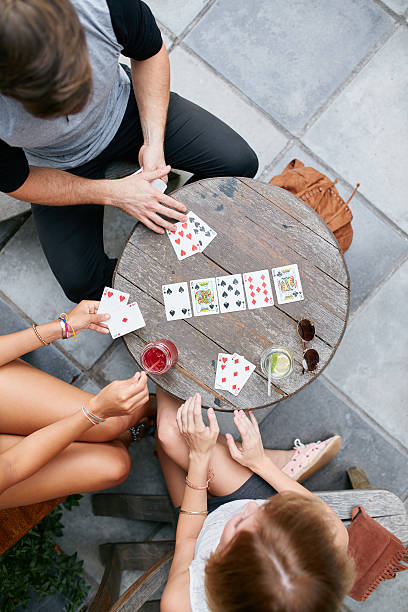 istock Young friends playing poker card game at cafe 499516916