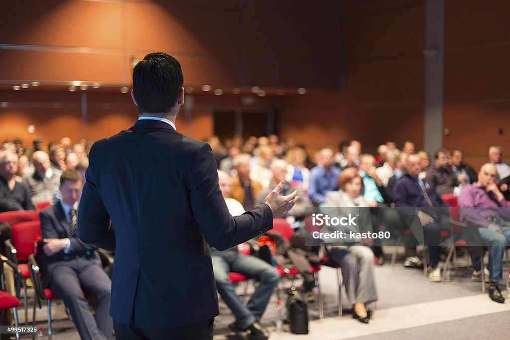 A man speaking at a business conference Speaker at Business Conference and Presentation. Audience at the conference hall. Meeting Stock Photo