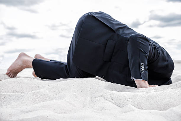 Hiding from his problems. Barefoot man in formalwear hiding his head in sand head in the sand stock pictures, royalty-free photos & images