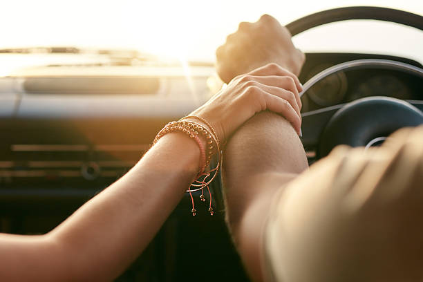 istock Couple traveling by car and holding hands 499517740
