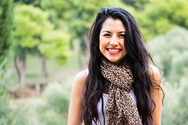 istock Young woman smiling with green background 499518459