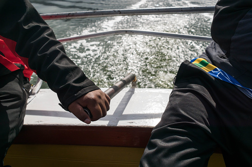 Steersman directs boat on Titicaca lake