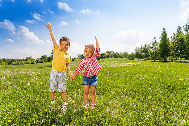 Cute boy and girl showing flowers in nature