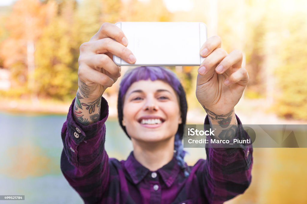 Hiker girl using smartphone at the mountain Girl taking "selfie" in the mountain, in front of the lake 2015 Stock Photo