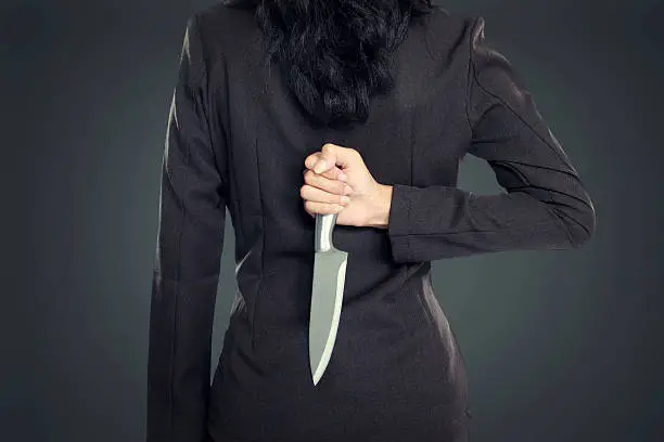 Business woman Holding Knife Behind His Back. conceptual image