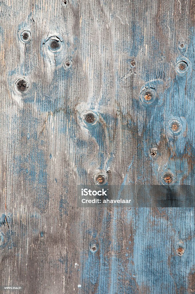 grey wooden board with knots and blue paint grey wooden board with knots and remnants of blue paint Backgrounds Stock Photo