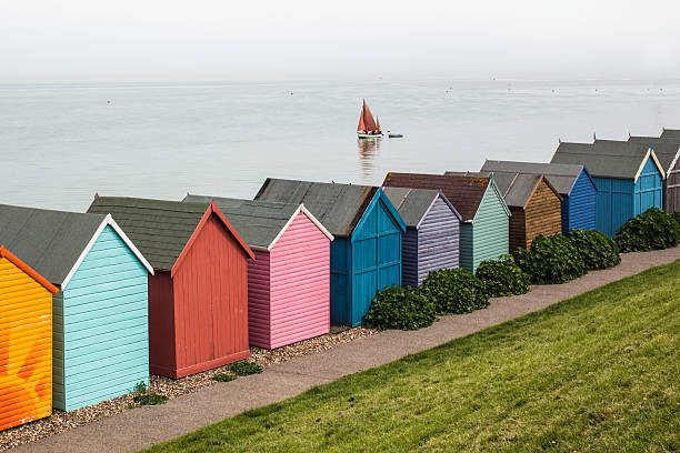 Beach huts and yacht in Kent beach huts and a yacht in Herne Bay, Kent, uk herne bay photos stock pictures, royalty-free photos & images