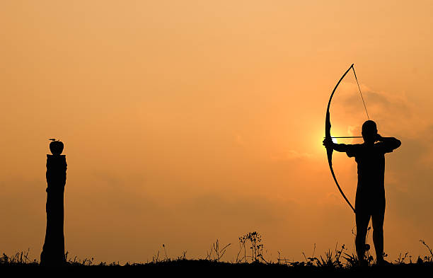 istock Silhouette archery shoots a bow at an apple on timber 499538320