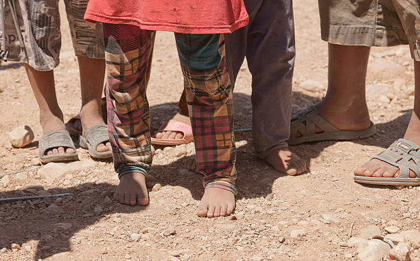 Feet of children in IDP camp stock photo