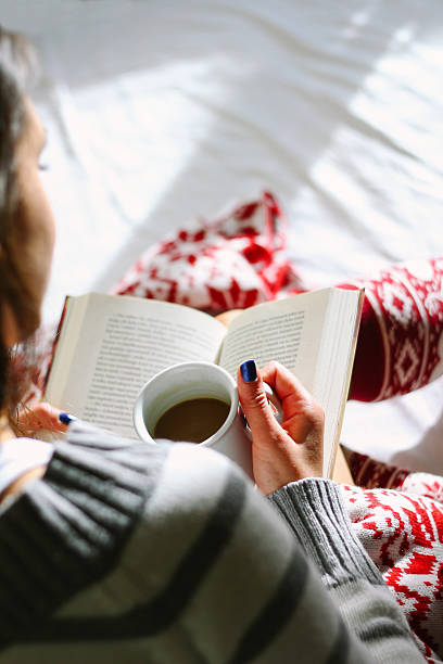 istock Girl in bed with coffee cup reading a book 499539552